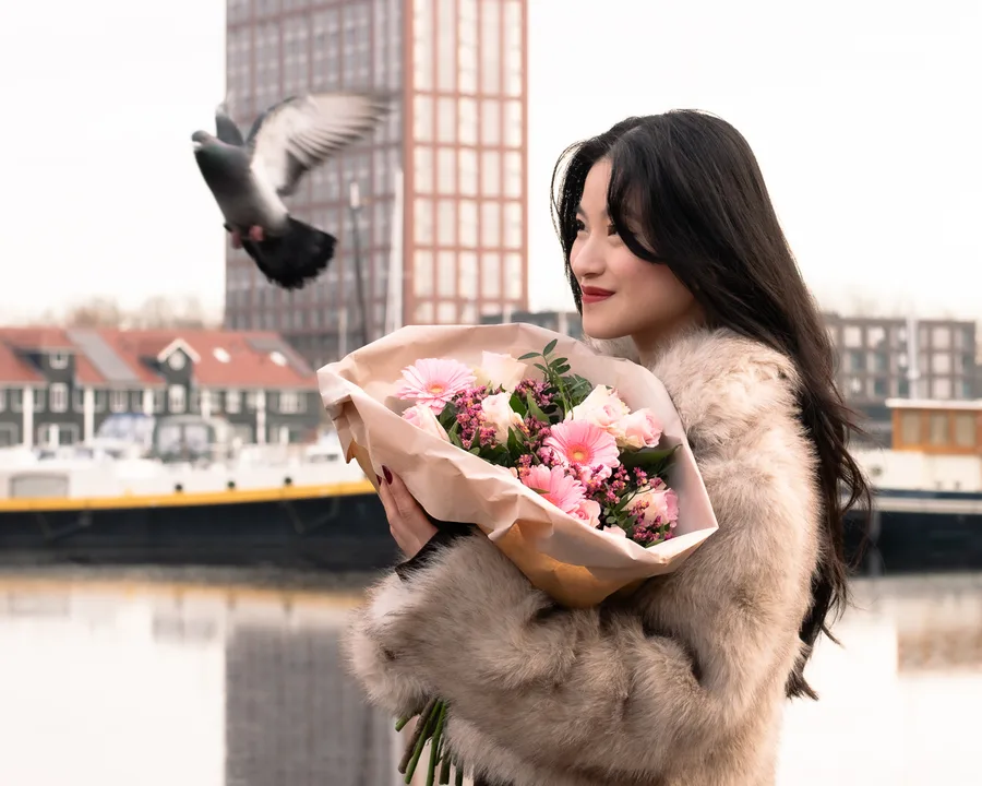 Portret met bloemen en een opvliegende vogel aan het water
