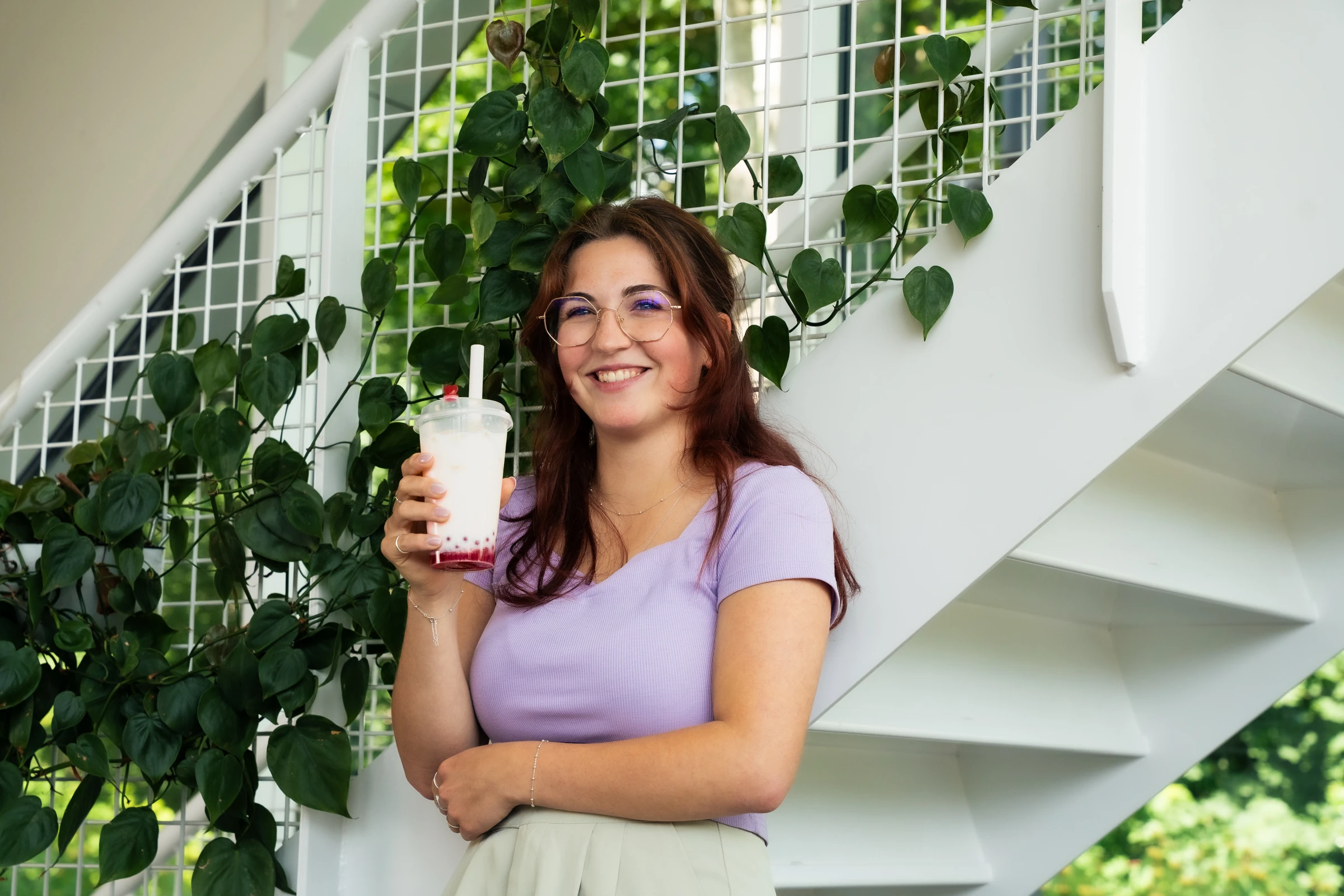 Een vrouw met haar bubble tea bij de trap bij GUOGUO